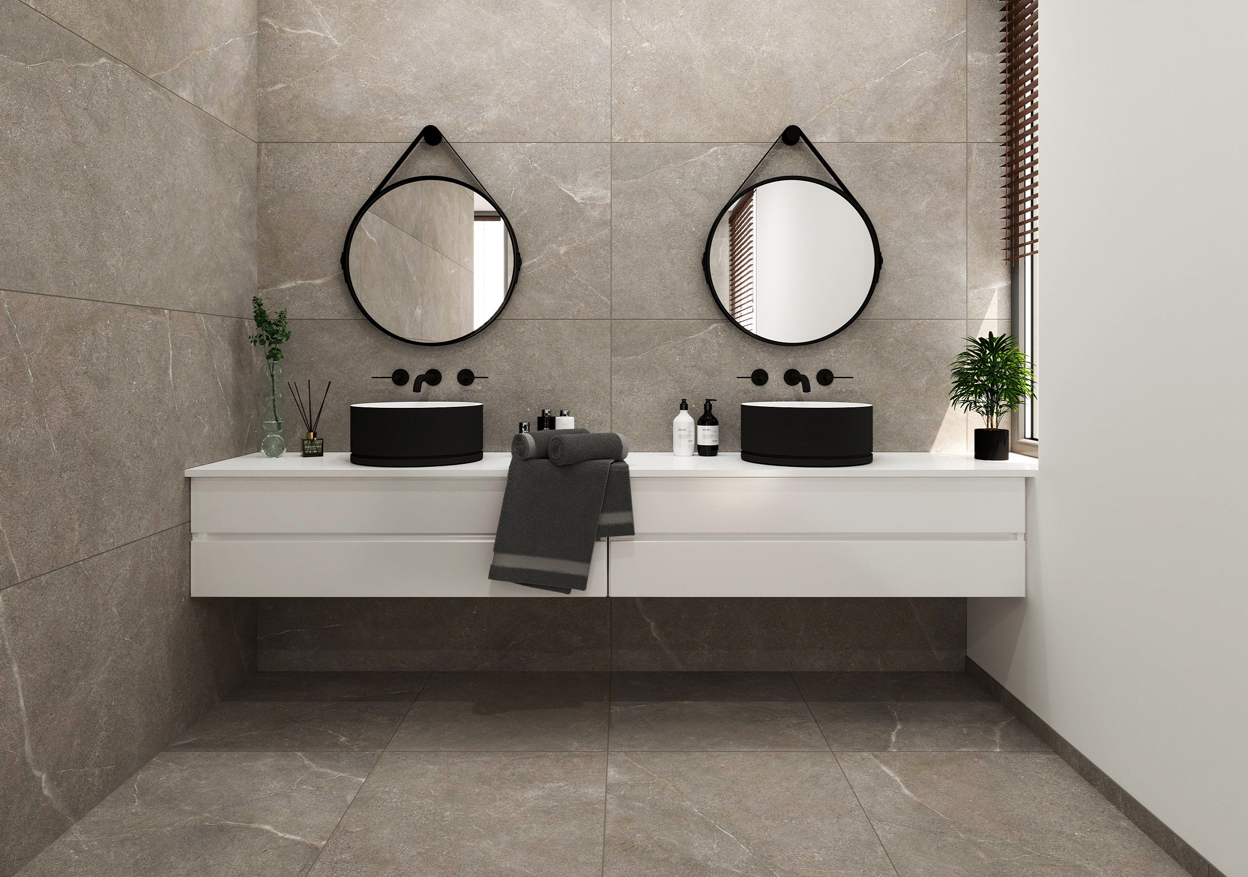 Modernes Badezimmer mit zwei runden Spiegeln, schwarzen Waschbecken und einem weißen Waschtisch. Dekorative Pflanzen und Pflegeprodukte sorgen für einen minimalistischen Look.