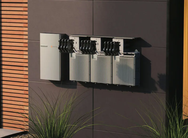 Solarbatteriespeicher und Wechselrichter an einer Wand eines modernen Gebäudes. Das System ist ordentlich montiert und zeigt eine effiziente Lösung für die Speicherung von Solarenergie.